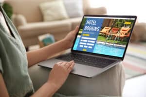 guest emailing hotel on laptop travel planning