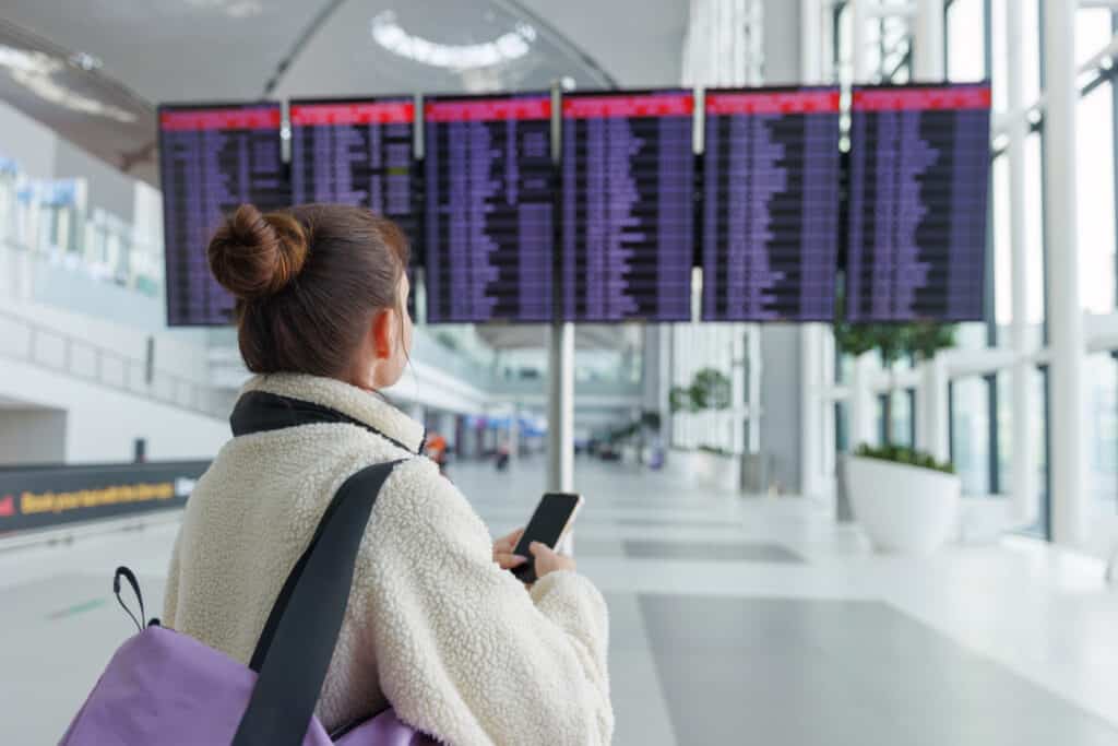 traveler looking at connecting flight board