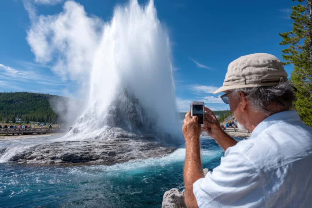 ocean blowhole spraying water tourist watching