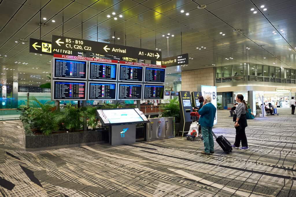 airport departures board delay flight travelers waiting