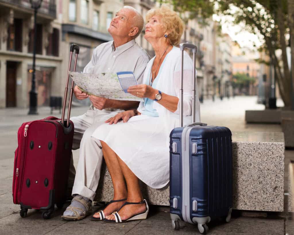 “retired couple packing suitcase thoughtful moment”