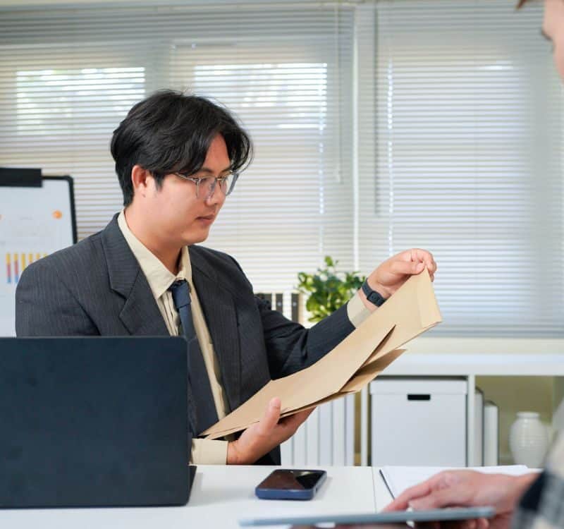 Application, hands and interview with business people in human resources office for hiring or recruitment. CV, documents or resume with manager and candidate talking in office for job opportunity.