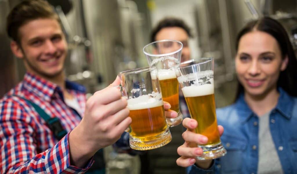 Brewers toasting beers at brewery factory