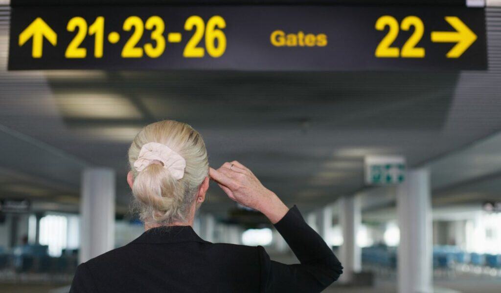 Businesswoman looking at directional sign in airport lounge