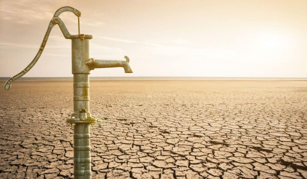 Dry cracked desert with old water pipe