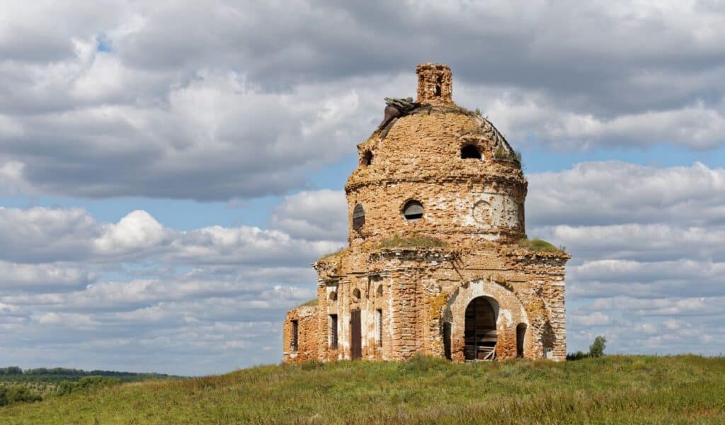 Old obsolete and abandoned church on the field