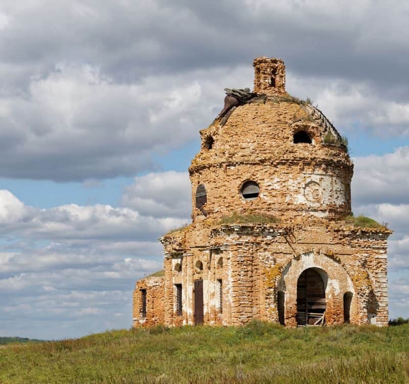 Old obsolete and abandoned church on the field