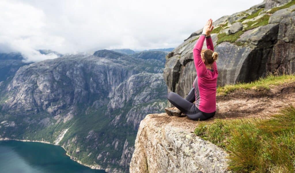 Young woman feel freedom on Kerag. Happy woman enjoy beautiful lake and good weather in Norway