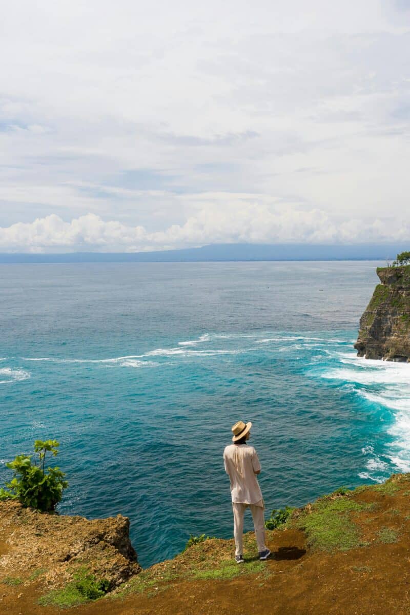 “tourist dangerously close cliff edge panorama
