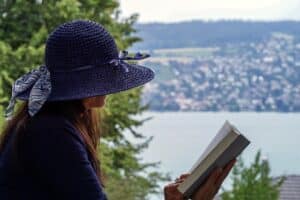 woman reading book while traveling