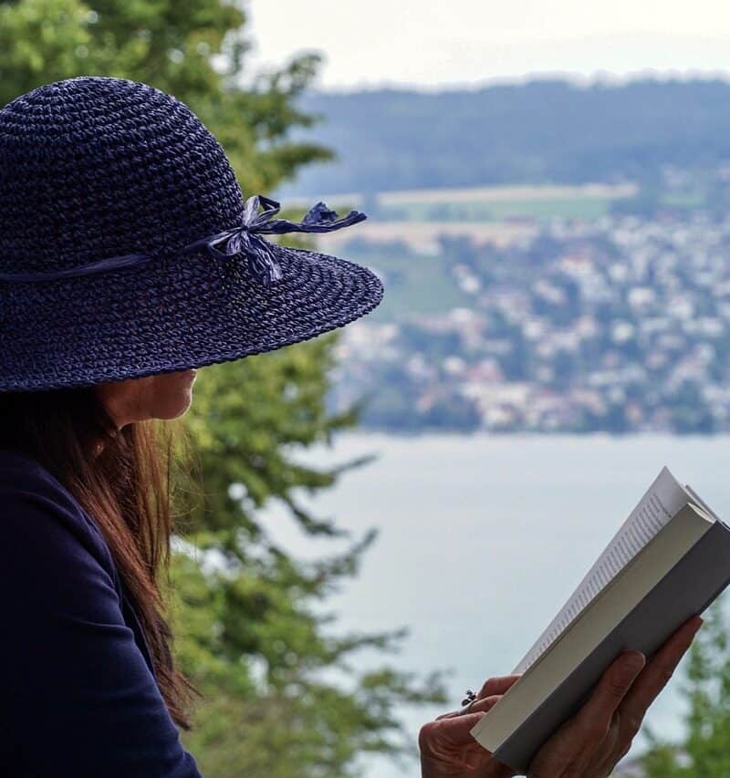 woman reading book while traveling