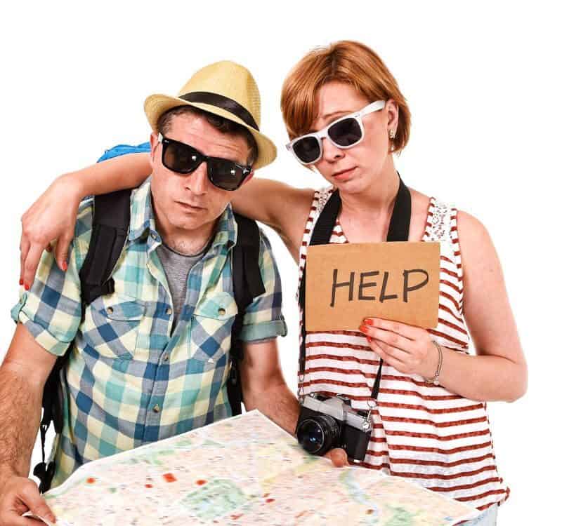 young tourist couple reading city map looking lost and confused loosing orientation with girl carrying travel backpack and man in frustrated face expression asking for help isolated in white