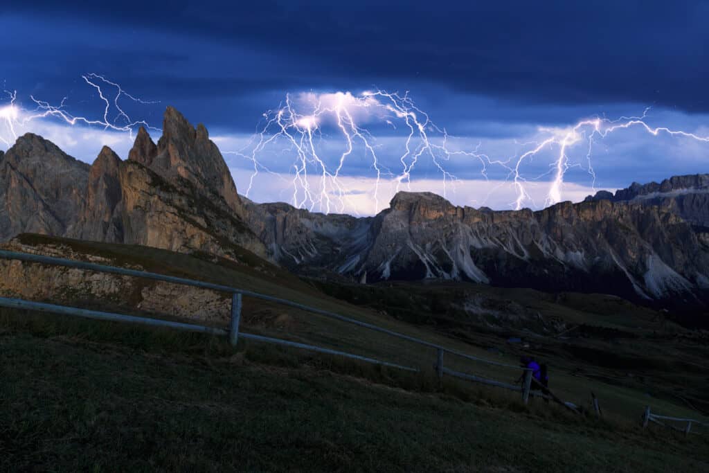 “lightning strike over mountain ridge hikers retreating”