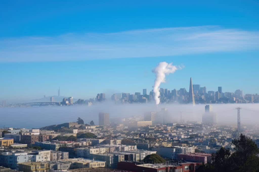 smoke plume and distant city skyline