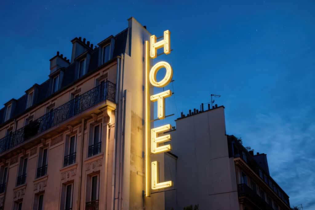 hotel neon sign glowing in twilight cityscape