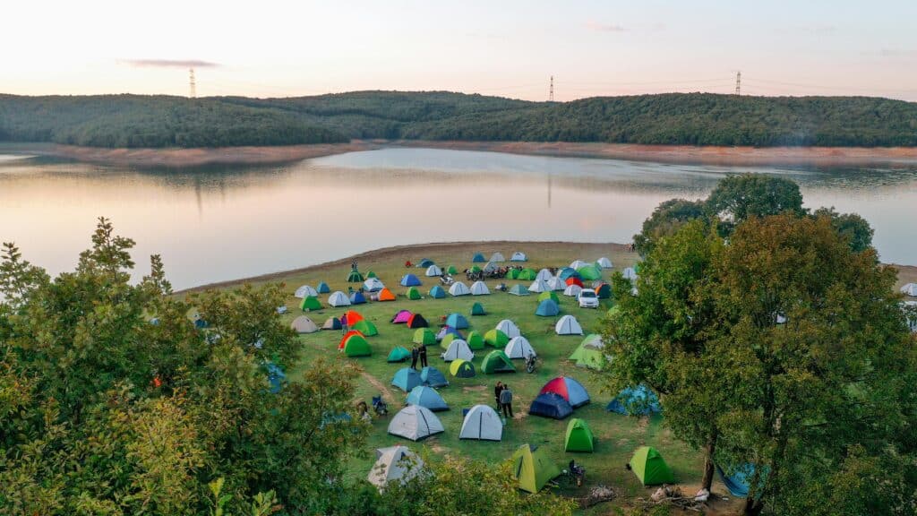 calm lakeside campsite with tents spaced apart at dusk