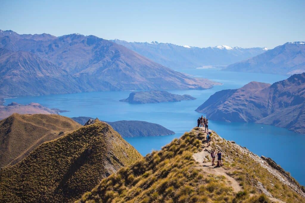 Scenic view of Lake Titicaca with mountains and hiking trail.