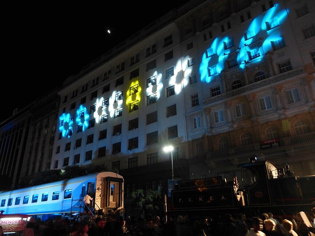 1024px-Tren_nuevo_vs_locomotora_antigua_-_Avenida_de_Mayo_-_Festejos_por_la_Revolución_de_Mayo_-_2015