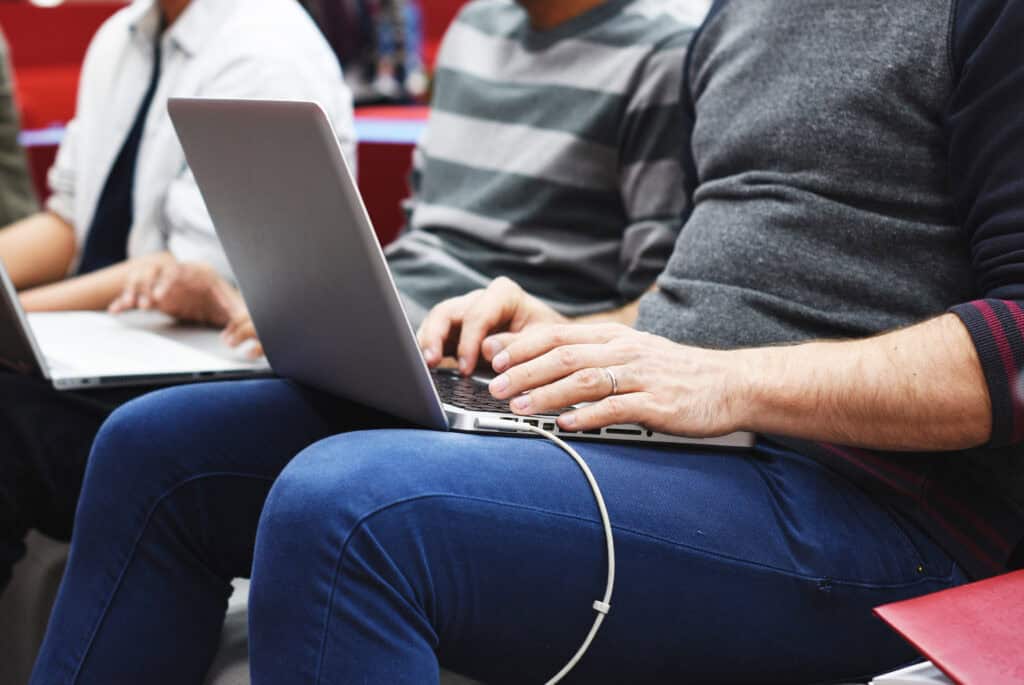 people using laptops close together airport