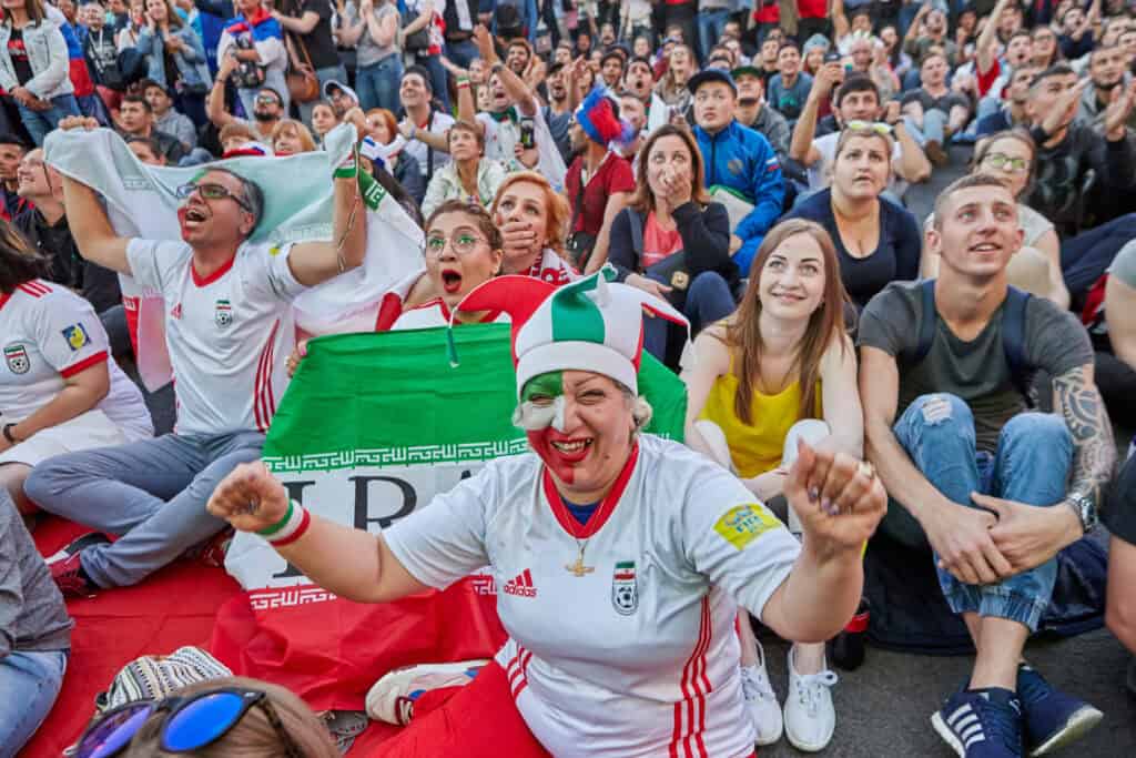 Iran football fans waving flag stadium