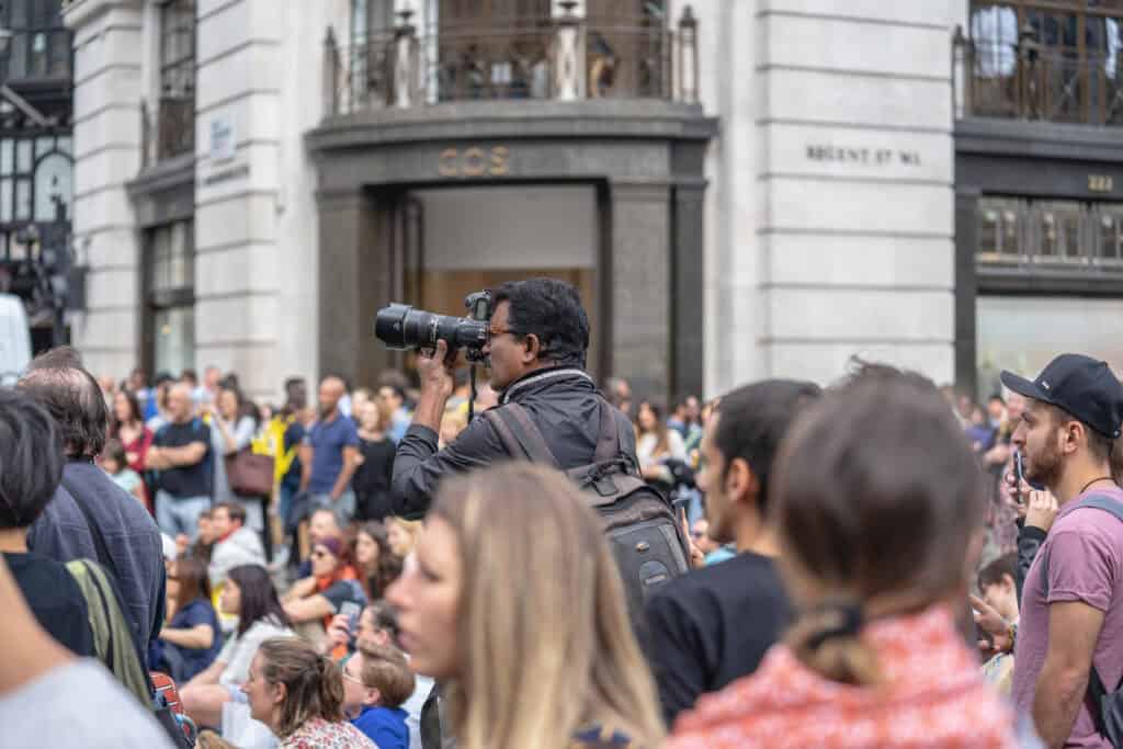 tourist holding expensive camera crowded street