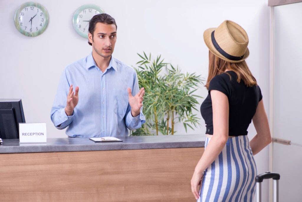 traveler speaking to hotel receptionist check-in