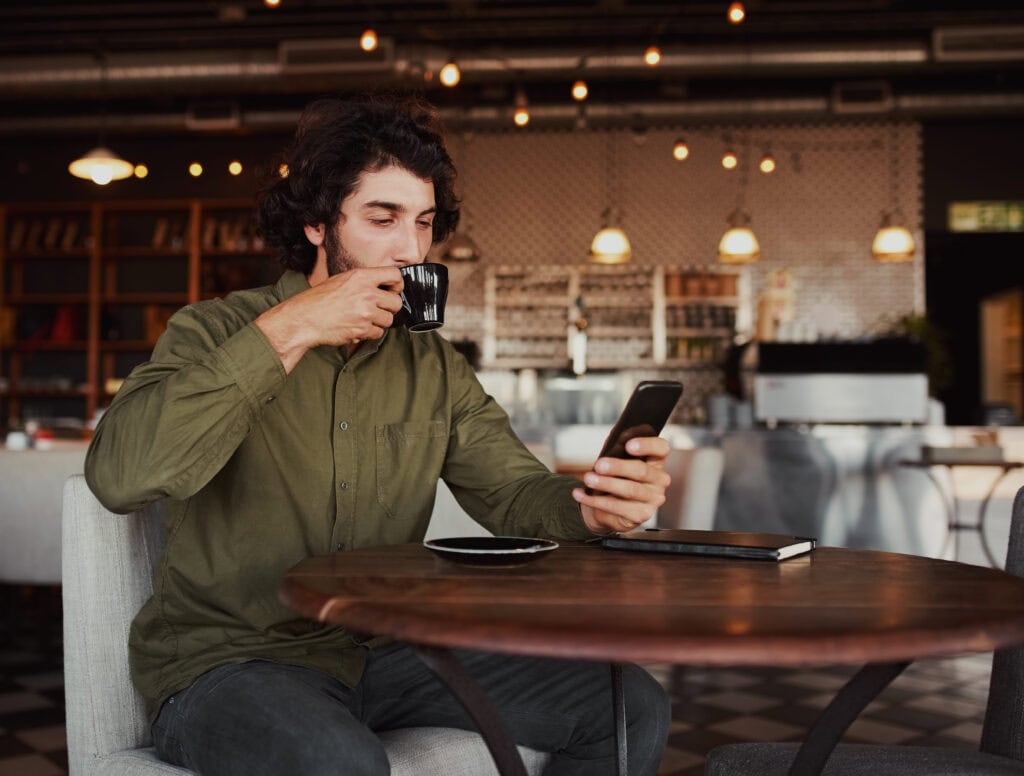 traveler reading news on phone café Europe