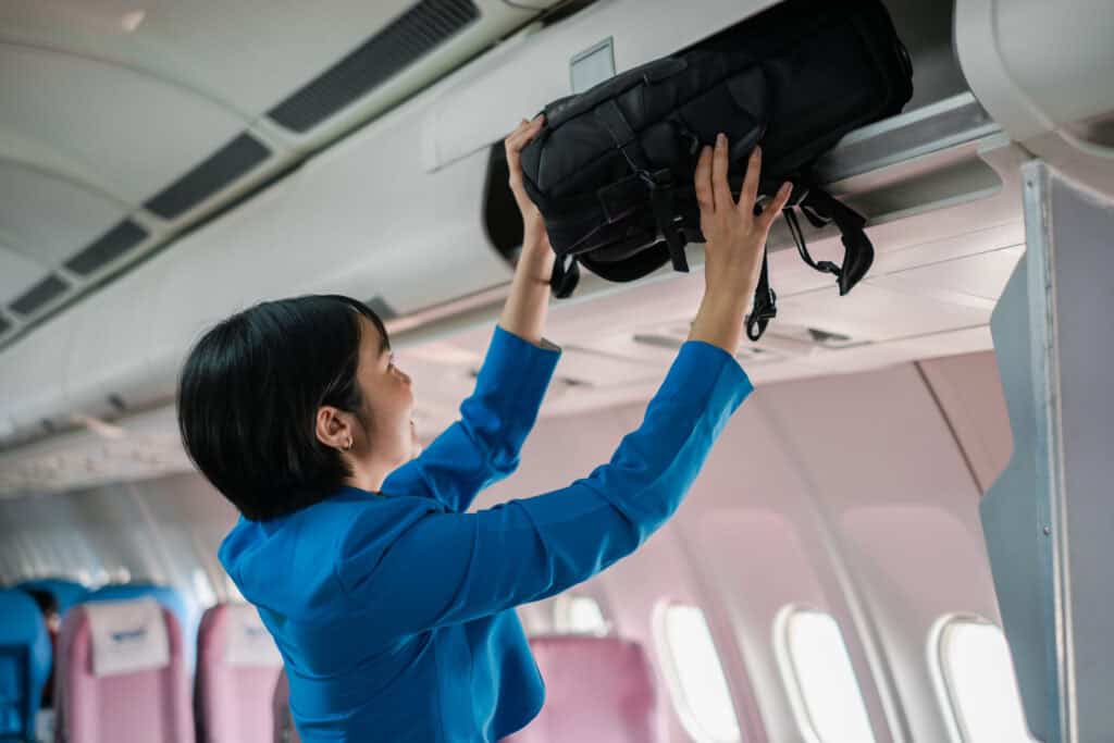 airplane overhead bin full luggage stuffing bag