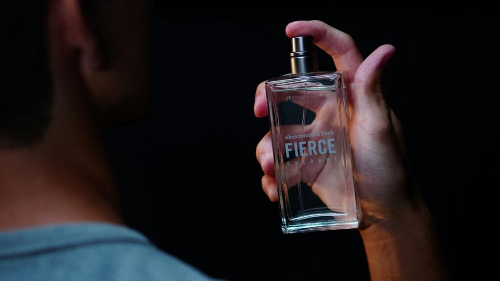 person spraying perfume travel
