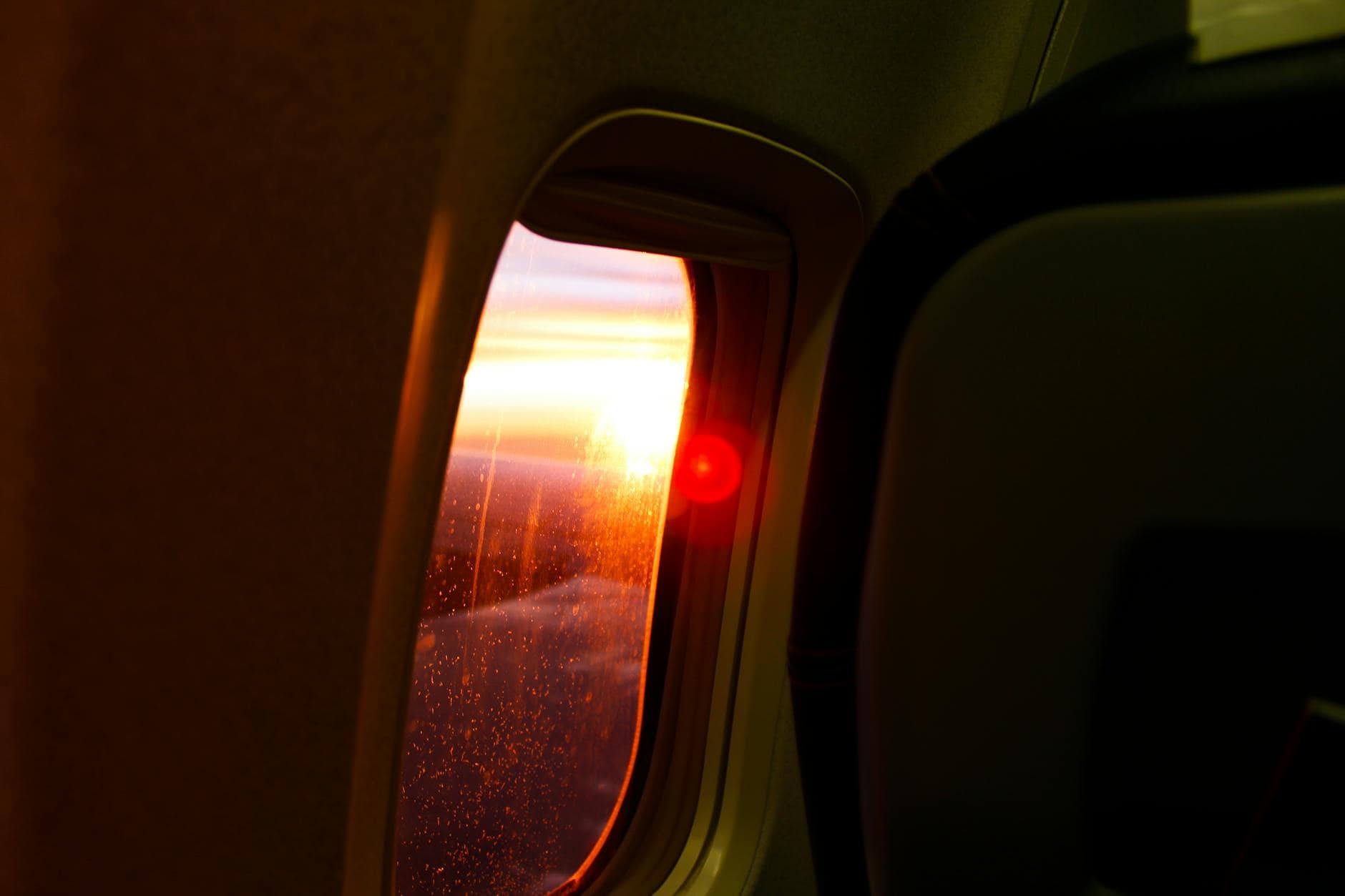 A stunning sunset view from an airplane window showcasing vivid skies and glowing horizon.