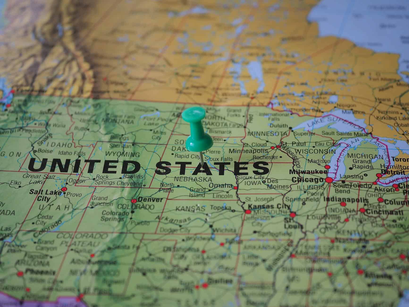 High-angle view of a map featuring the United States with a green pin indicating a specific location.