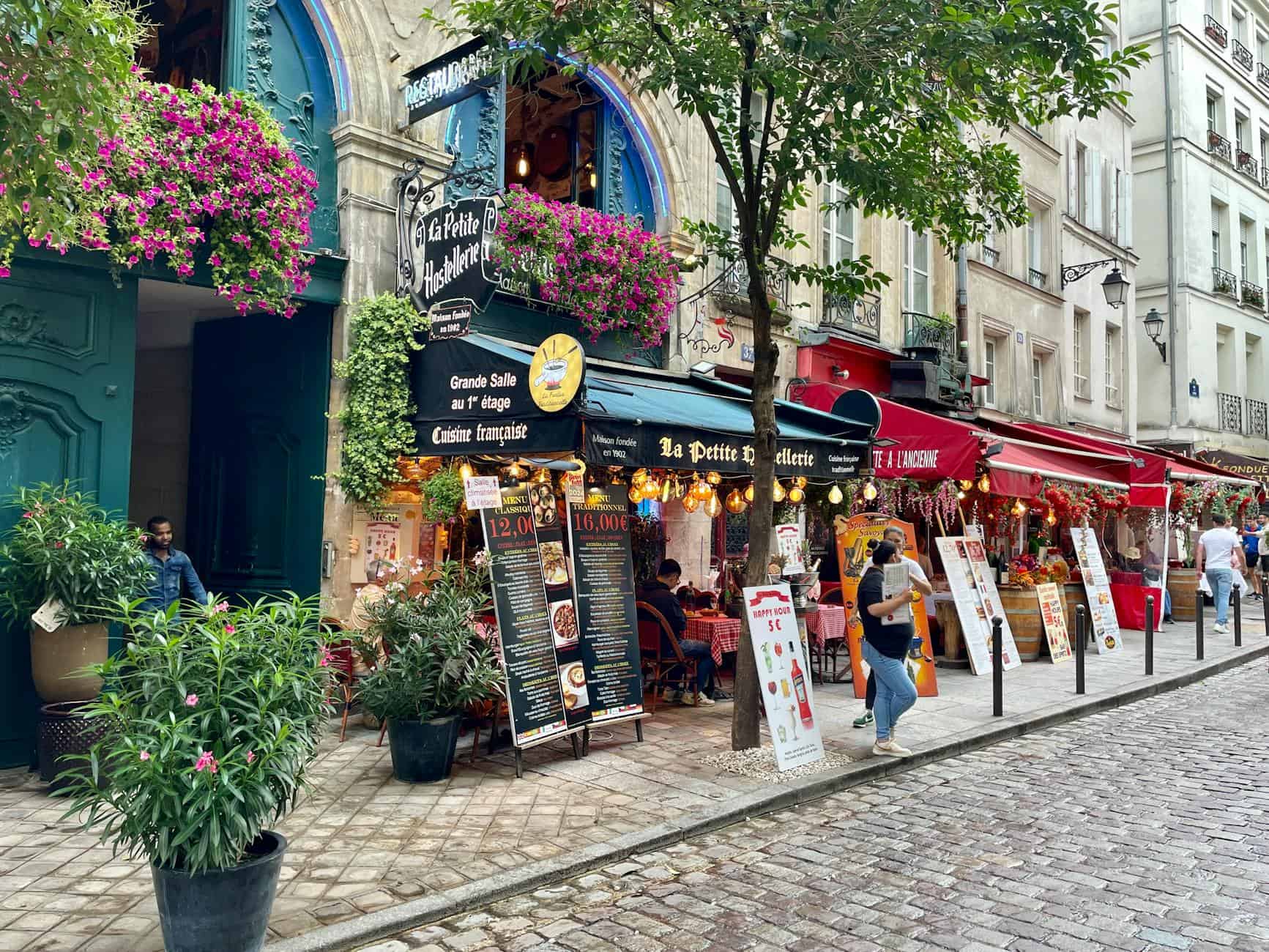 Delightful street view of Parisian cafes with vibrant flowers on a summer day.