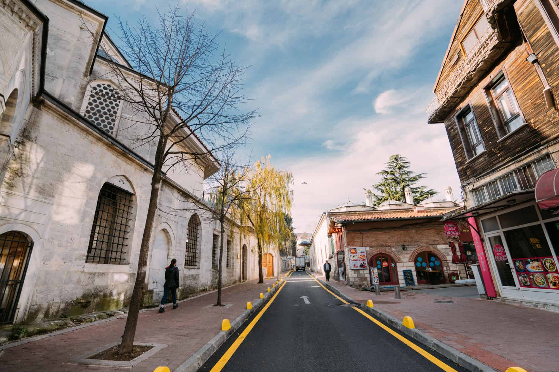A picturesque scene of an empty urban street with historic buildings and a clear sky.