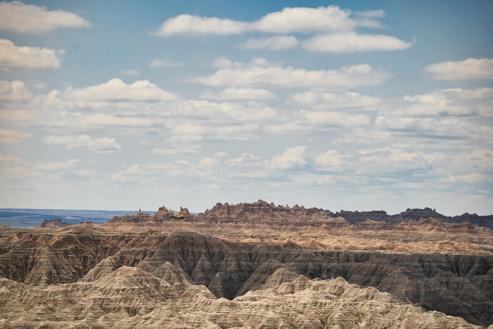 Dramatic landscape of Badlands National Park under a cloudy sky.
