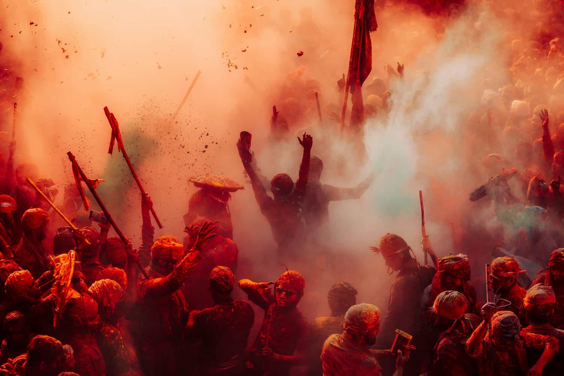 Colorful Holi celebration with people covered in powders and smoke in India.
