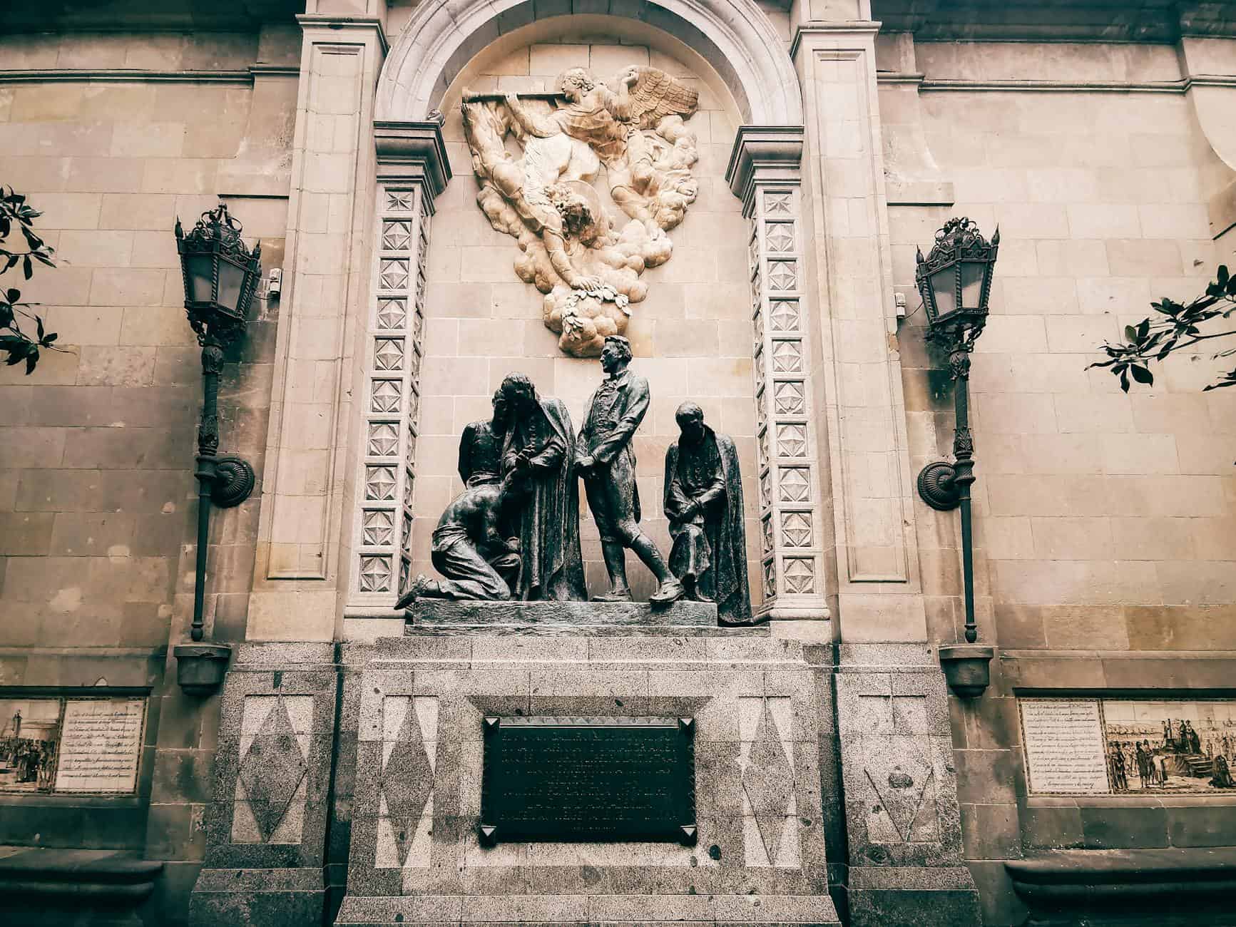 A detailed view of a historic monument featuring intricate sculptures and decorative elements on a wall.