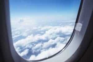 Breathtaking view of clouds and blue sky through an airplane window during flight.
