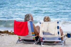 Senior couple relaxing on Miami Beach, enjoying the ocean view and summer sunshine.