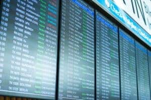 Digital screens display flight information and schedules at an airport terminal.