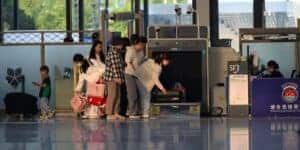 Travelers undergo security screening at an airport terminal.