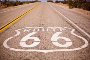 A classic view of Route 66 stretching into the horizon through a desert landscape.