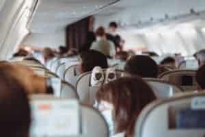 View of passengers wearing masks and seated in economy class during flight.