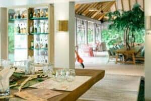 Bright and airy open-air restaurant with elegant table setting and bar display.