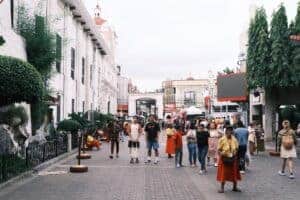 Crowded urban street with diverse people amidst historical architecture.