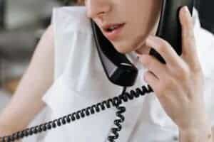 Close-up of a woman talking on a phone in an office setting.
