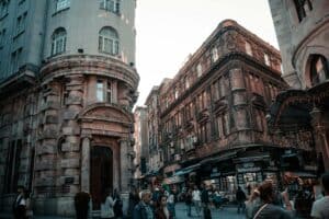 A busy street with historic European buildings and people passing by, showcasing urban lifestyle.