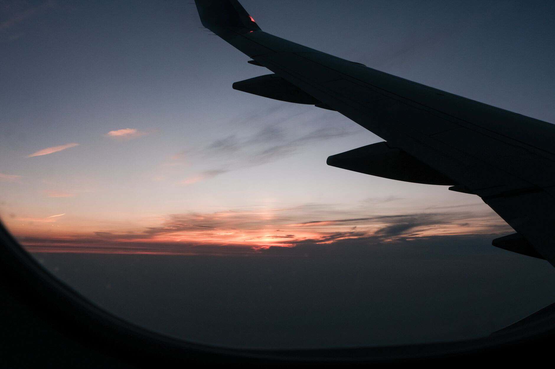 Airplane wing with a breathtaking sunset seen through the window, ideal for travel themes.