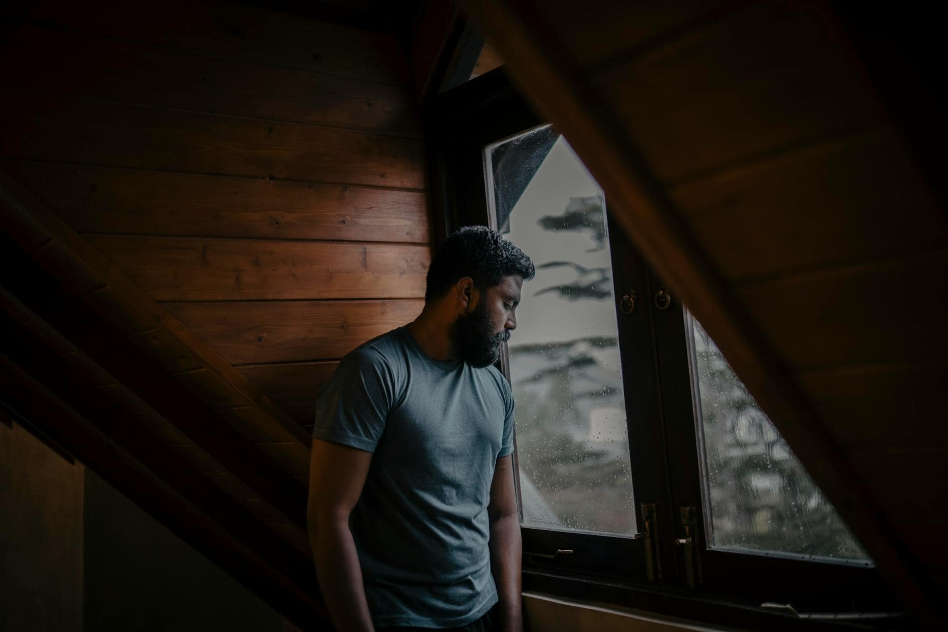 person looking out window sad