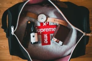 A stylish collection of travel essentials including a watch, wallet, and luxury items in a bag.