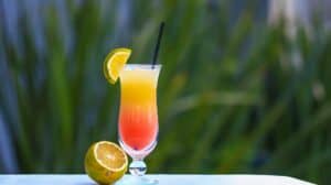 Vibrant citrus cocktail in a clear glass with a lemon slice garnish, perfect for summer refreshment.